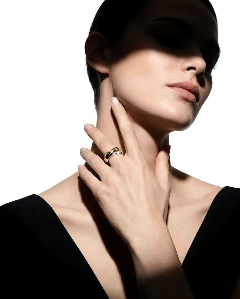 A ring on a hand framing a model’s jaw